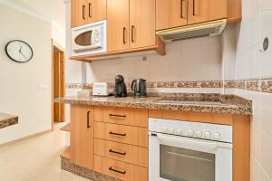 a kitchen with a stove and a microwave at Apartamento Fernandita in Nerja