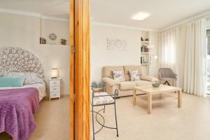 a bedroom with a bed and a couch and a table at Apartamento Fernandita in Nerja
