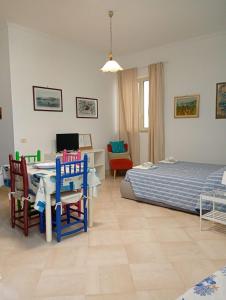 a bedroom with a bed and a table and chairs at Maison d'O in Otranto