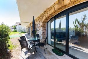 a stone walled patio with a table and chairs at Beach Pearl Cala de Mijas in Mijas
