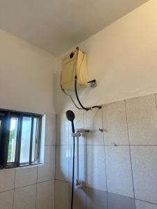 a bathroom with a shower with a blow dryer on the wall at Deckon in Avéméné +10 photos