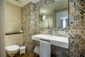 a bathroom with a sink and a toilet and a mirror at Apartament Massanet 1b in Canyamel +18 photos