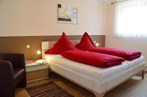a bedroom with red pillows on a white bed at Zipperhof in Lahr