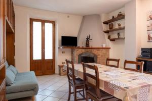 a dining room with a table and a fireplace at Casa Isidora in Acquaviva