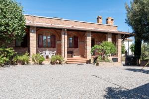 an old brick house with a driveway in front of it at Casa Isidora in Acquaviva