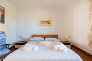 a bedroom with a large bed with towels on it at Casa Fortuna in Gallipoli