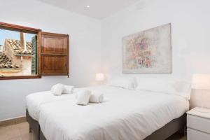 a bedroom with two white beds and a window at Maca Sol in Campanet