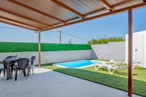 a patio with a table and chairs and a swimming pool at La Teja 3 - Solo Familias in Vejer de la Frontera