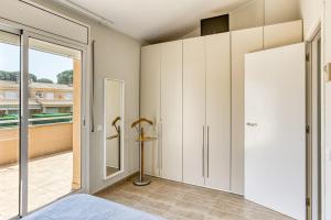 a bedroom with white cabinets and a sliding glass door at Pinamar casa con piscina in L'Escala +22 photos