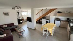a living room with a yellow table and a kitchen at Gite L'atelier De Théophile in Peltre
