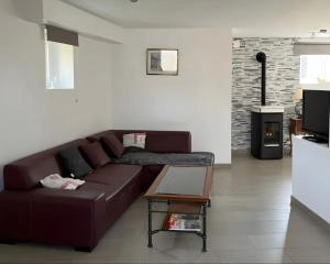 a living room with a brown couch and a table at Gite L'atelier De Théophile in Peltre