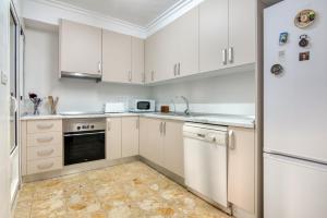 a kitchen with white cabinets and a refrigerator at Paseo el Saladar in Denia