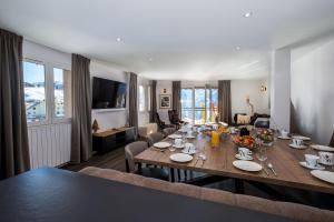 a dining room with a large wooden table with chairs at Triplex By Popalp in LʼHuez
