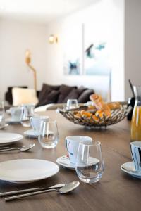 a wooden table with plates and wine glasses on it at Triplex By Popalp in LʼHuez +28 photos