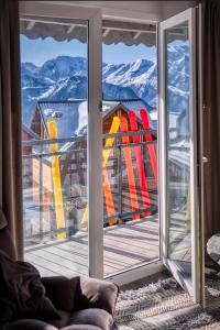 a sliding glass door with a view of a snow covered mountain at Triplex By Popalp in LʼHuez