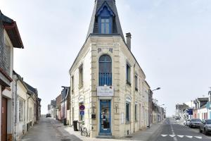 a tall building with a steeple on a street at La Pointe Du Crotoy in Le Crotoy