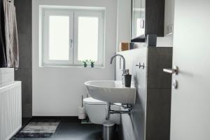 a white bathroom with a sink and a toilet at Ferienwohnung Schwalbenflug in Naumburg +13 photos