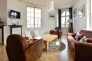 a living room with couches and a wooden table at La Pointe Du Crotoy in Le Crotoy