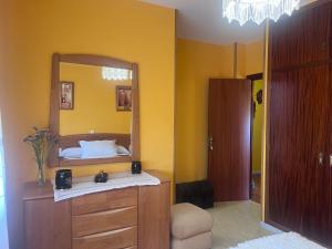 a bedroom with a mirror and a dresser with a bed at Villa Neli Playa in Foz +23 photos