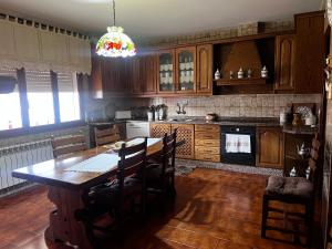 a kitchen with a table and chairs and a chandelier at Villa Neli Playa in Foz