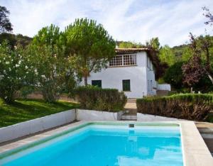 eine Villa mit Swimmingpool vor einem Haus in der Unterkunft Collado in Alájar