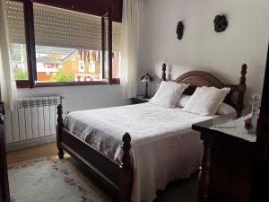 a bedroom with a large bed with a window at Villa Neli Playa in Foz