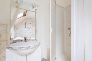 a bathroom with a sink and a mirror at Appart Cancale Centre-ville - Mer in Cancale +7 photos