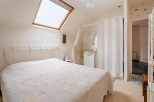 a bedroom with a large bed and a window at Appart Cancale Centre-ville - Mer in Cancale
