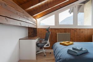 a bedroom with a bed and a desk and a chair at Railway Loft Dimaro I By Immobilux in Monclassico