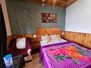 a bedroom with a pink bed and a chair at Smarthill Deodar Echoes in Dalhousie