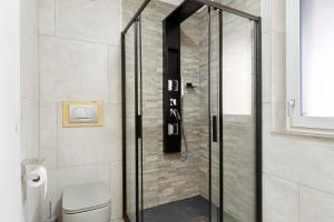 a shower with a glass door in a bathroom at Railway Loft Dimaro I By Immobilux in Monclassico +24 photos