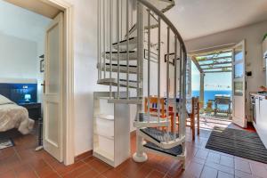 a spiral staircase in a room with a view of the ocean at Casa Ebaté in Chiessi