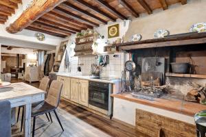 a kitchen with a stove and a table with chairs at Casa Collicello relax in Camaiore