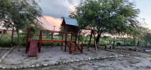 ein Spielplatz mit Rutsche und Baum in der Unterkunft Cabañas Termas in Termas de Río Hondo