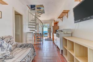 a living room with a tv and a spiral staircase at Casa Ebaté in Chiessi