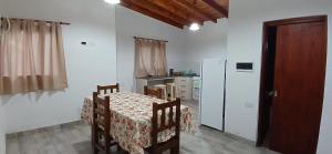 ein Esszimmer mit einem Tisch und einem Kühlschrank in der Unterkunft Cabañas Termas in Termas de Río Hondo