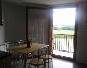 ein Esszimmer mit Tisch und Stühlen und einem Balkon in der Unterkunft Ultzama in Iráizoz