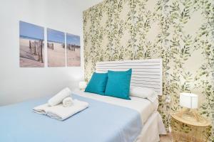 a bedroom with a bed with blue and white pillows at Apartamento Gondolas Costa Tropical in Almuñécar +23 photos