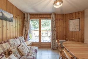 a living room with a couch and a table at L’Edelweiss Pied des Pistes in Morillon