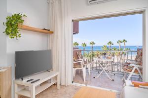 a living room with a tv and a balcony at Apartamento Gondolas Costa Tropical in Almuñécar