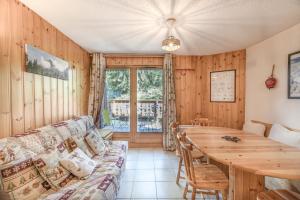 a living room with a couch and a wooden table at L’Edelweiss Pied des Pistes in Morillon