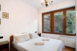a bedroom with a bed with white sheets and a window at Alassio Holiday in Alassio