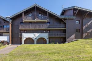 an apartment building with a balcony and a yard at L’Edelweiss Pied des Pistes in Morillon +12 photos