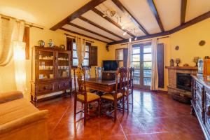 a living room with a wooden table and chairs at Casa Rural De Cabrera in Urrez +27 photos