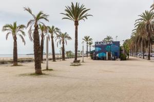 a beach with palm trees and a building at Sant Pere in Mataró +12 photos