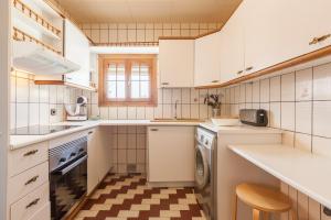 a kitchen with white cabinets and a sink and a dishwasher at Sant Pere in Mataró