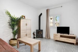 a living room with a couch and a tv at Villa Montenmedio 2 in El Soto
