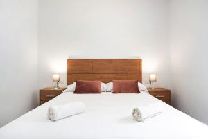 a bedroom with a large white bed with two lamps at Villa Montenmedio 2 in El Soto +17 photos