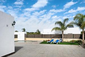 two blue chairs in a courtyard with palm trees at Villa Montenmedio 2 in El Soto