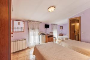 a hotel room with two beds and a refrigerator at El Tejado in Maluenda